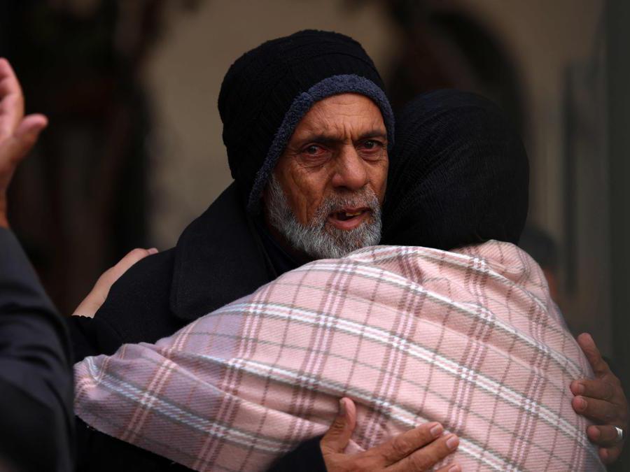 EDITORS NOTE: Graphic content / The father (L) of woman from the Palestinian Sheikh el-Eed family, killed along with her two children a day earlier when their home was hit by Israeli bombardment on Rafah in the southern Gaza Strip, receives condolences on November 19, 2023, as battles continue between Israel and the Palestinian militant group Hamas. (Photo by SAID KHATIB / AFP)