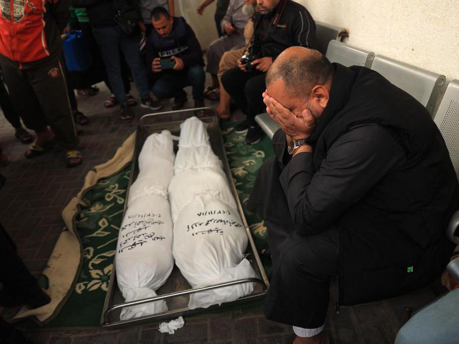EDITORS NOTE: Graphic content / A man mourns over the bodies of a woman and her child from the Palestinian Sheikh el-Eed family, killed along with another child from the household a day earlier, when their home was hit by Israeli bombardment on Rafah in the southern Gaza strip, on November 19, 2023, as battles continue between Israel and the Palestinian militant group Hamas. (Photo by SAID KHATIB / AFP)