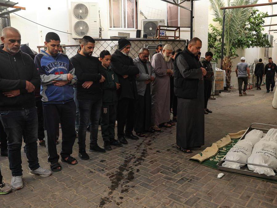 EDITORS NOTE: Graphic content / People pray over the bodies of a woman and her child from the Palestinian Sheikh el-Eed family, killed along with another child from the household a day earlier, when their home was hit by Israeli bombardment on Rafah in the southern Gaza Strip, outside the morgue of the al-Najjar hospital, on November 19, 2023, as battles continue between Israel and the Palestinian militant group Hamas. (Photo by SAID KHATIB / AFP)