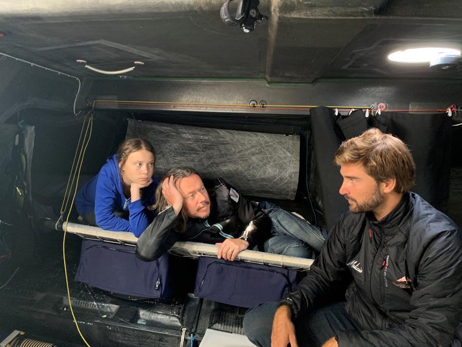 L'attivista per ilclima Greta Thunberg, suo padre Svante  (centro) e lo skipper Boris Herrmann (destra) siedono a bordo dello yacht  Malizia II. Team Malizia/Handout via REUTERS