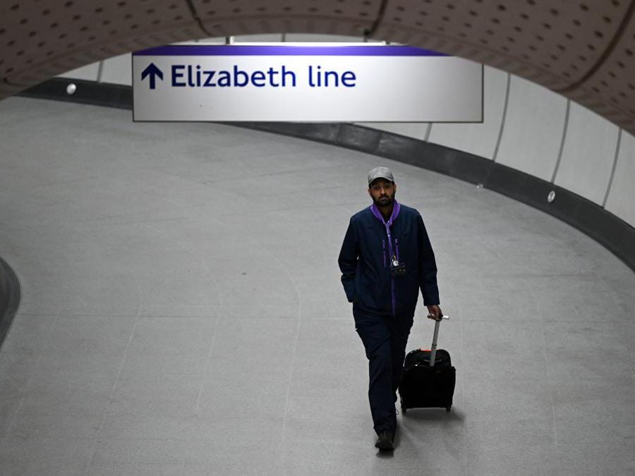 Un lavoratore cammina attraverso un tunnel alla stazione di Liverpool Street durante una corsa di prova di un treno della linea Elizabeth Transport for London (TfL) tra la stazione di Paddington e la stazione di Liverpool Street e ritorno (Justin Tallis/Afp)