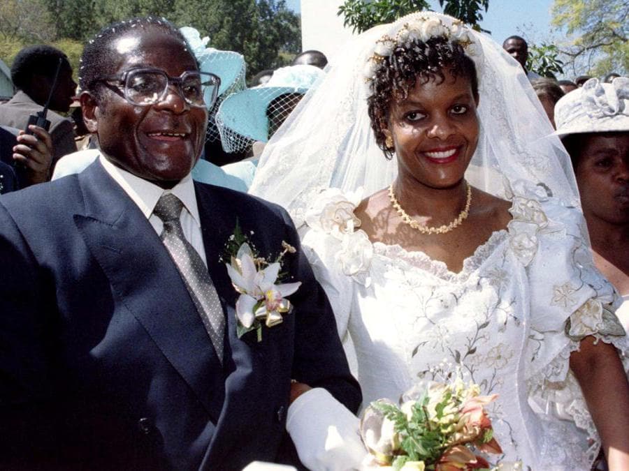 Il presidente Robert Mugabe e la nuova moglie Grace lasciano la chiesa cattolica di Kutama nello Zimbabwe il 17 agosto 1996 dopo aver scambiato i voti nuziali. REUTERS/Howard Burditt/File Photo