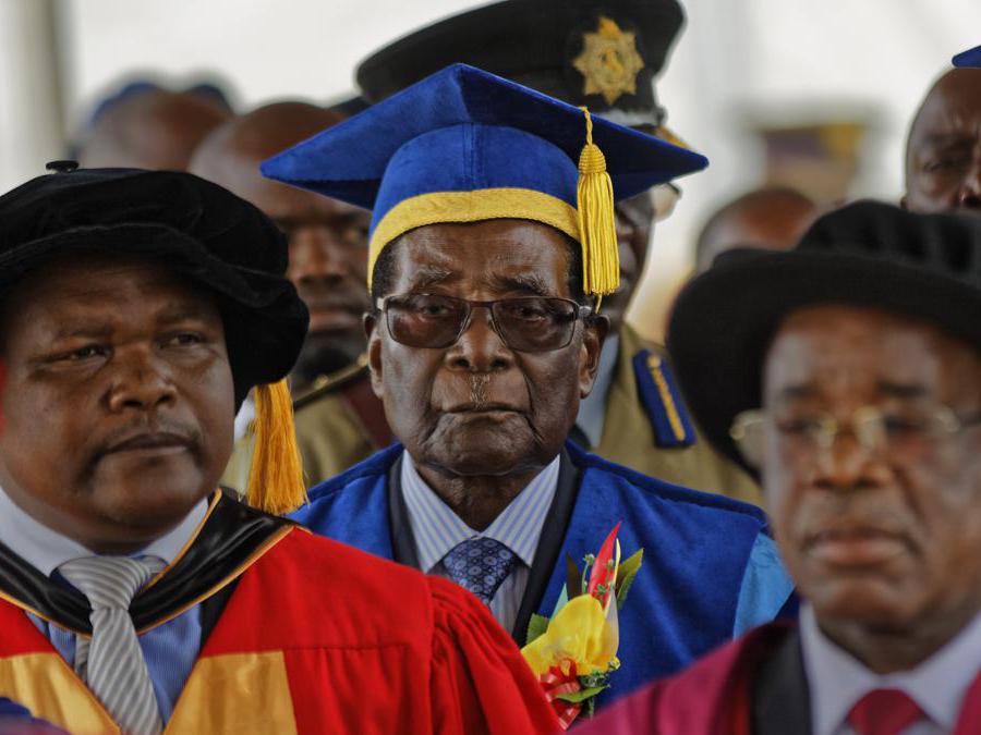 17 novembre 2017. Il presidente dello Zimbabwe, Robert Mugabe, al centro, arriva per presiedere a una cerimonia di laurea degli studenti presso la Zimbabwe Open University alla periferia di Harare, Zimbabwe. (AP Photo/Ben Curtis, File)