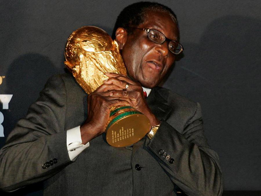 Il presidente dello Zimbabwe, Robert Mugabe, stringe il trofeo della Coppa del Mondo di calcio FIFA all'aeroporto internazionale di Harare, 26 novembre 2009. REUTERS/Philimon Bulawayo/File Photo