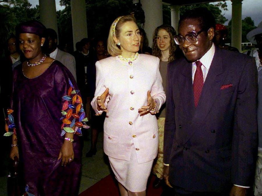 La First Lady americana Hillary Clinton (centro) è scortata dal presidente dello Zimbabwe Robert Mugabe (destra) e da sua moglie Grace Mugabe dopo essere arrivata al palazzo presidenziale di Harare il 21 marzo 1997. REUTERS/Win McNamee/File Photo