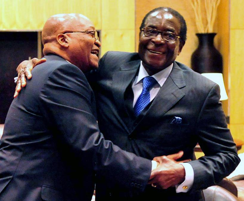 Una foto distribuita dal governo sudafricano mostra il presidente sudafricano Jacob Zuma (sinistra) e il presidente dello Zimbabwe Robert Mugabe (destra) che si abbracciano durante una riunione straordinaria della SA Development Community (SADC) presso il Sandton Convention Center di Johannesburg, in Sudafrica, il 20 giugno 2009 .EPA