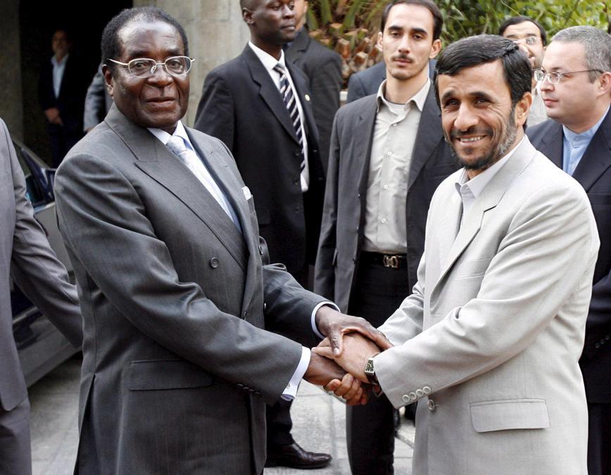 Il presidente iraniano Mahmoud Ahmadinejad (destra) stringe la mano al presidente dello Zimbabwe Robert Mugabe (sinistra) presso l'ufficio presidenziale di Teheran, Iran, 20 novembre 2006 . EPA/ABEDIN TAHERKENAREH