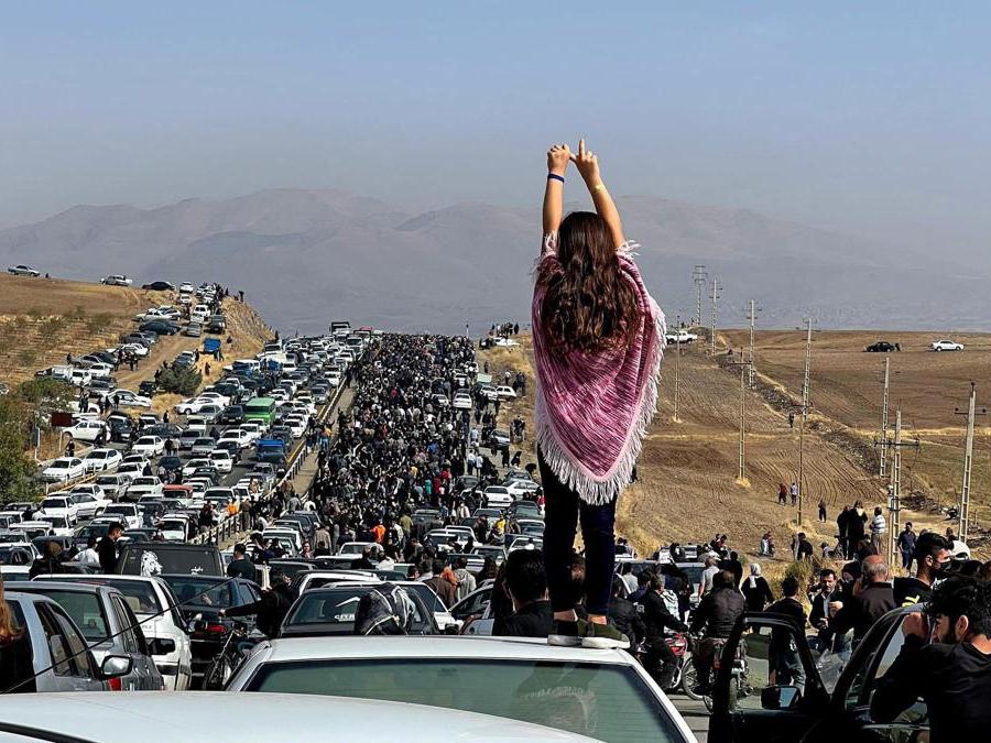 Questa immagine pubblicata su Twitter, secondo quanto riferito, il 26 ottobre 2022 mostra una donna senza velo in piedi in cima a un veicolo mentre migliaia di persone si dirigono verso il cimitero di Aichi a Saqez, la città natale di Mahsa Amini nella provincia iraniana occidentale del Kurdistan (Ugc/Afp)