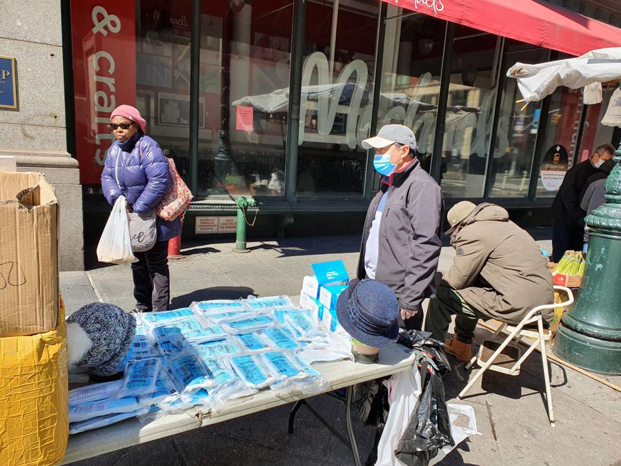 Sulla 6Th Avenue una bancarella improvvisata vende mascherine a un dollaro.