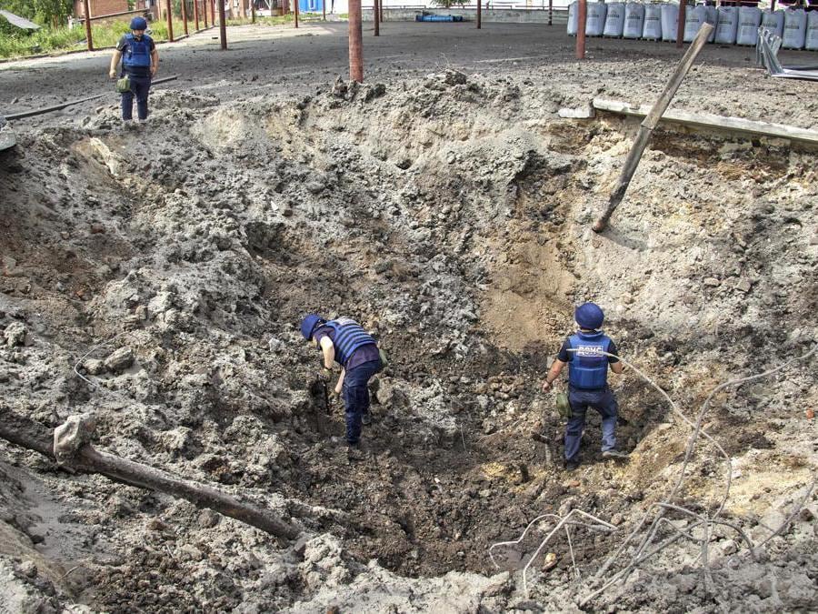Merefa, nei pressi di Kharkiv, soccorritori ucraini ispezionano il cratere provocato da un missile russo (EPA/SERGEY KOZLOV)