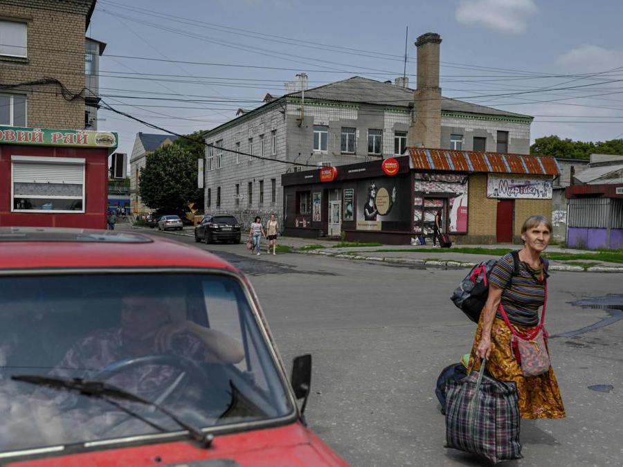 Una donna si reca alla stazione di Pokrovsk, Ucraina orientale (Photo by BULENT KILIC / AFP)