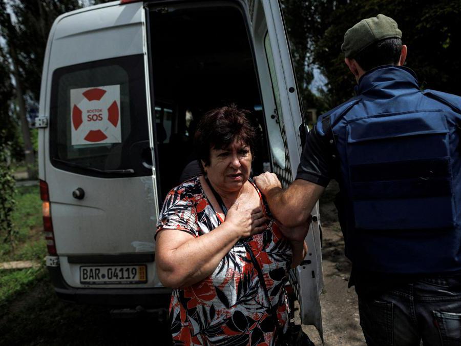 Bakhmut, la moglie del civile ucraino appena colpito da un ictus viene rassicurata dai volontari dell’ONG "Vostok SOS" (REUTERS/Alkis Konstantinidis)