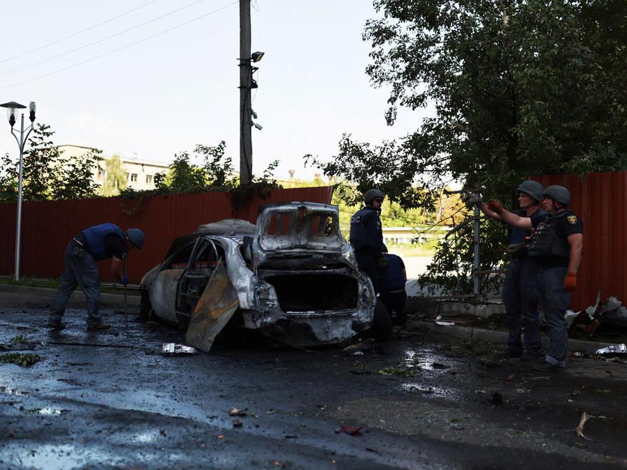 Poliziotti vicino a una macchina distrutta da un bombardamento (REUTERS/Nacho Doce)