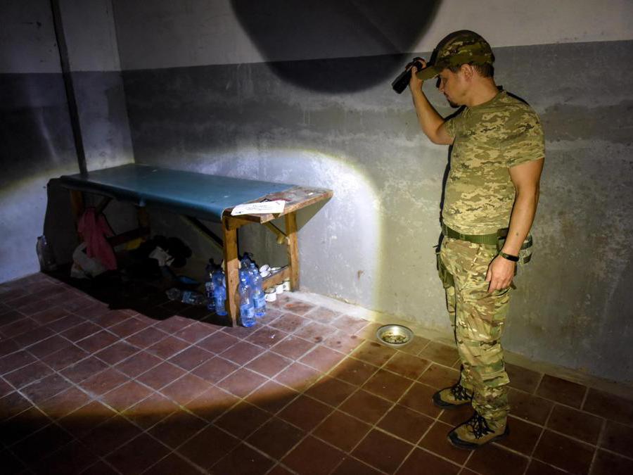 Un militare ucraino mostra una delle stanze presumibilmente utilizzata come prigione per militari e civili ucraini a Vovchansk, nella regione di Kharkiv. (Epa/ Oleg  Petrasyuk)