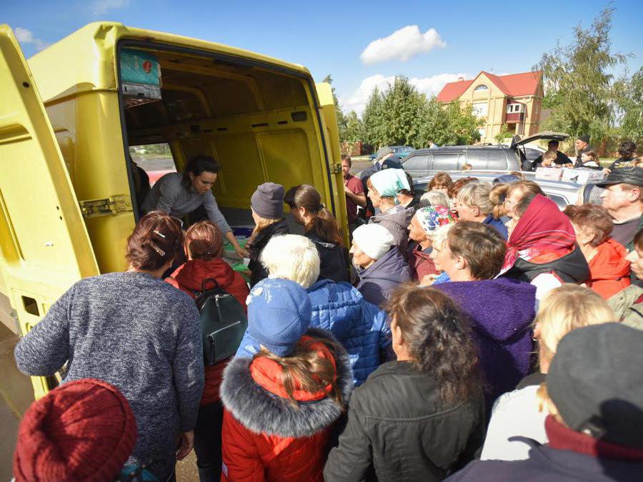 Le persone ricevono aiuti umanitari nel villaggio di Prykolotne, nella regione di Kharkiv. (Epa/ Oleg  Petrasyuk) 