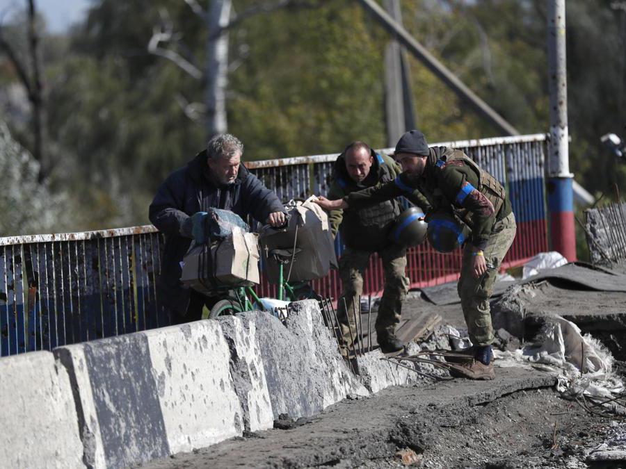 Kupiansk, est di Kharkiv, soldati ucraini assistono un’anziana su un ponte danneggiato dai bombardamenti (EPA/ATEF SAFADI)