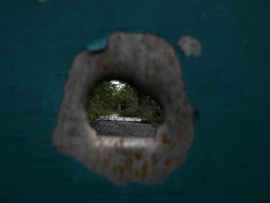Il foro di un proiettile sulla porta di una casa a Zakitne, Ucraina orientale  (Photo by Juan BARRETO / AFP)