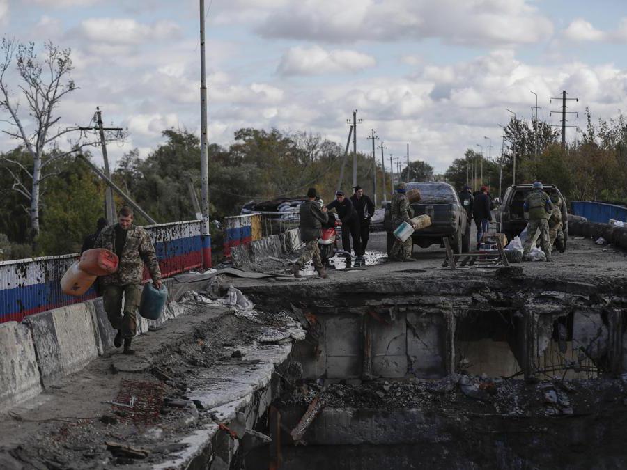 Soldati ucraini trasportano scorte alimentari attraverso il ponte danneggiato di Kupiansk, est di Kharkiv (EPA/ATEF SAFADI)