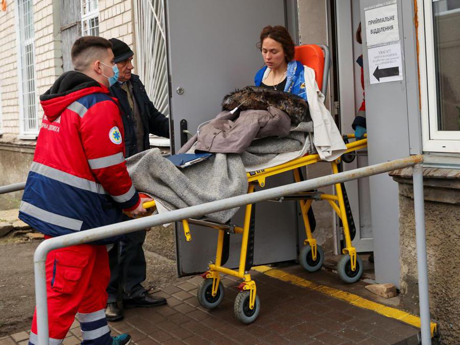 Gli operatori sanitari aiutano una donna ferita mentre arriva in ospedale dopo che un elicottero è caduto su edifici delle infrastrutture civili, durante l’attacco della Russia all’Ucraina, a Kiev, in Ucraina (Reuter/Nacho Doce)