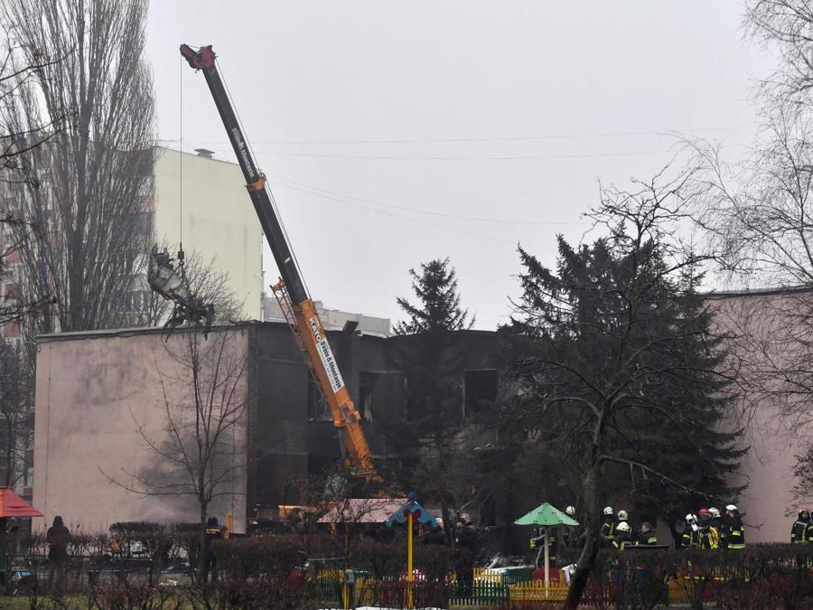 Una parte dell’elicottero precipitato vicino a un asilo viene rimossa mentre i soccorritori lavorano a Brovary, fuori dalla capitale Kiev (Afp/Sergei Supinsky)