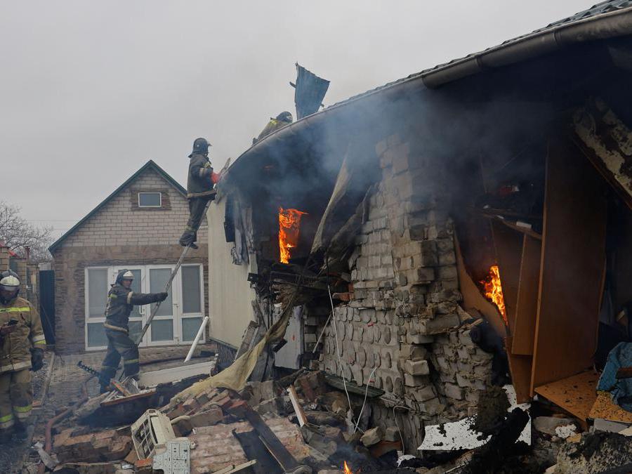 Firefighters work to extinguish fire amidst debris of a house destroyed by recent shelling in the course of Russia-Ukraine conflict in the city of Khartsyzk, in the Donetsk region, Russian-controlled Ukraine, March 18, 2023. REUTERS/Alexander Ermochenko