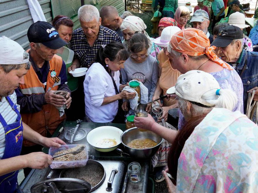 Mariupol, volontari distribuiscono cibo alla popolazione (Photo by STRINGER / AFP)