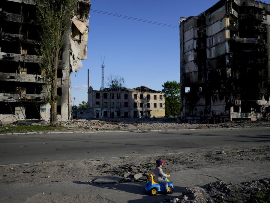 Un ragazzo gioca davanti alle case distrutte dai bombardamenti a Borodyanka, in Ucraina  (AP Photo/Natacha Pisarenko)