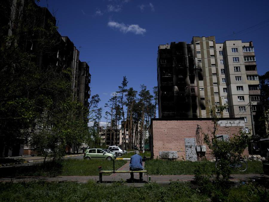 Un residente siede fuori dagli edifici danneggiati dai bombardamenti a Irpin, periferia di Kiev (AP Photo/Natacha Pisarenko)