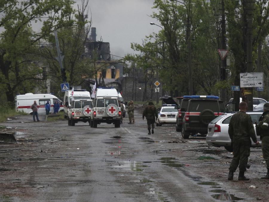 Membri della Croce Rossa osservano l’evacuazione dei militari ucraini dalla Azovstal di Mariupol (AP Photo)