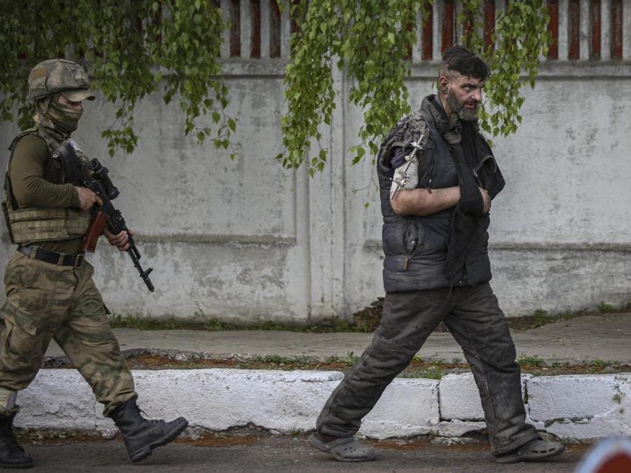 Un militare della autoproclamata Repubblica Popolare di Donetsk scorta uno dei soldati ucraini usciti dalla Azovstal di Mariupol (EPA/ALESSANDRO GUERRA)
