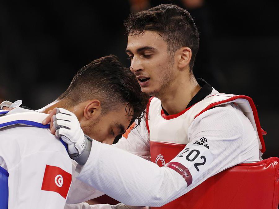 epa09362204 Vito Dell'Aquila (R) of Italy consoles Mohamed Khalil Jendoubi (L) of Tunisia after his loss during their bout in the Taekwondo Men's -58kg Gold Medal Contest of the Tokyo 2020 Olympic Games at the Makuhari Messe convention centre in Chiba, Japan, 24 July 2021. EPA/RUNGROJ YONGRIT
