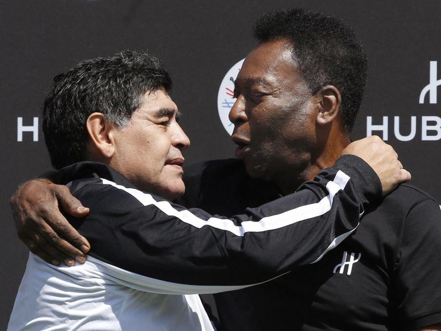 Diego Maradona con Pelé.  (Photo by PATRICK KOVARIK / AFP)