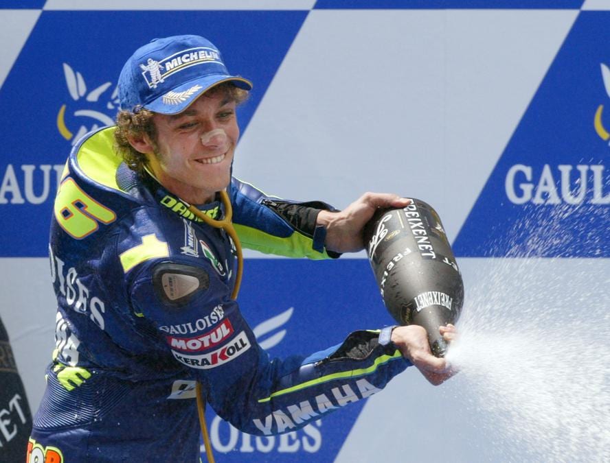 Valentino Rossi sul podio dopo aver vinto la gara MotoGP di Catalunya sul circuito di Montmelo, vicino a Barcellona, Spagna, 13 giugno 2004. Valentino ha vinto la gara, il pilota spagnolo Sete Gibernau è arrivato secondo e l’italiano Marco Melandri terzo (REUTERS/Gustau Nacarino GN/AA)